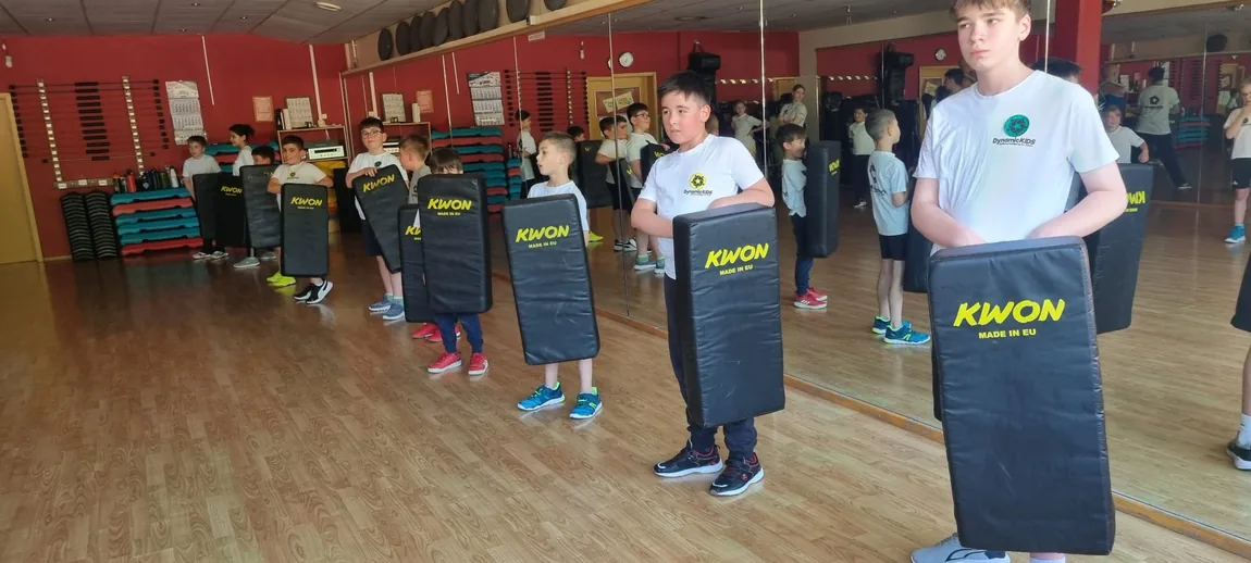 Kinder bereiten sich im Training mit Schlagpolstern auf Partnerübungen vor